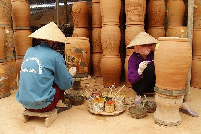 Các nghệ nhân đang trang trí hoa văn trên các sản phẩm gốm