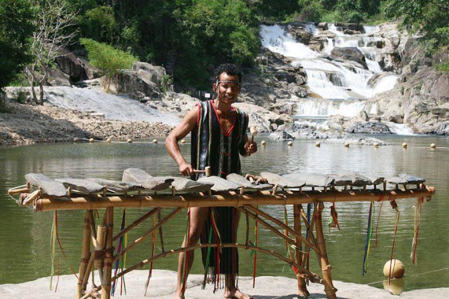 Nghệ nhân đánh đàn đá dưới chân thác Yang Bay