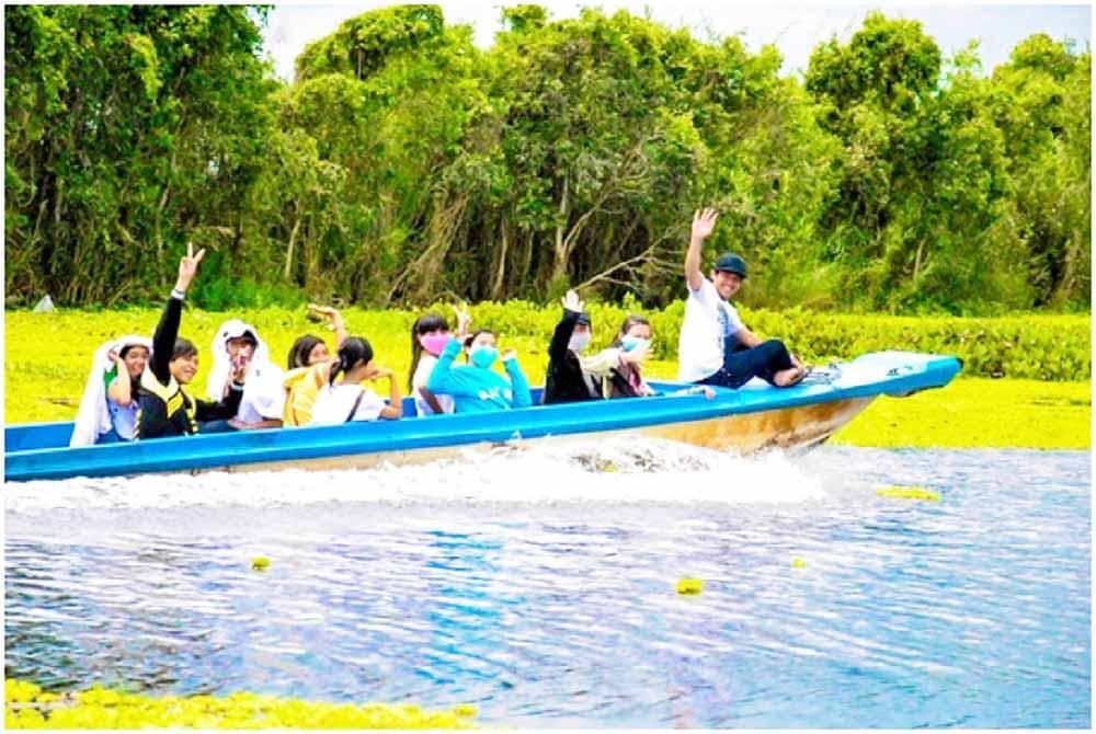 Du khách ngồi thuyền vỏ lãi du ngoạn rừng U Minh